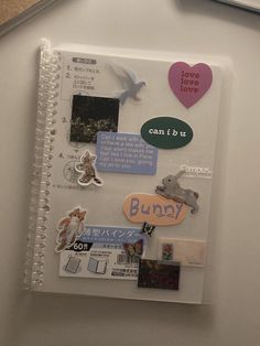 an open notebook with stickers and magnets on it