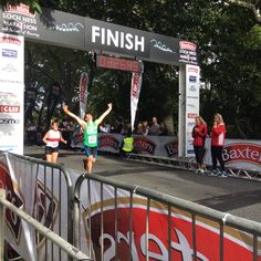 a woman crosses the finish line with her arms in the air