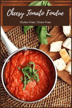 a bowl filled with tomato sauce next to bread