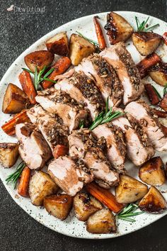 a white plate topped with meat, potatoes and carrots