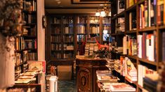 a library filled with lots of books next to a tall wooden book shelf full of books