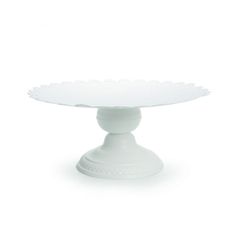 a white cake plate with scalloped edges on an oval base, isolated against a white background