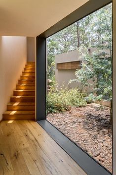 the inside of a house with wood floors and stairs leading up to an outside area