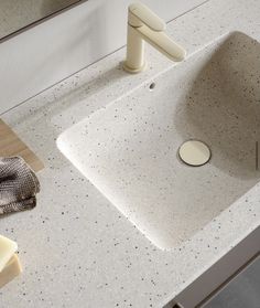 a white sink sitting on top of a counter next to a towel and soap dispenser