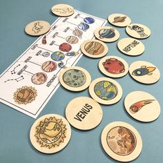 wooden magnets with pictures of planets and their names are on a blue table top