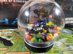 a close up of a gummy ball on a table with a game in the background