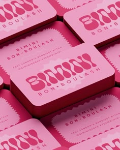 pink business cards stacked on top of each other with the word boooo in red