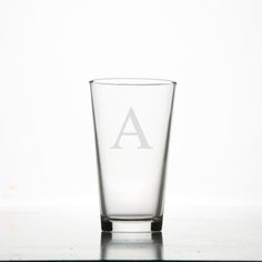 a shot glass with the letter a on it sitting on a counter top in front of a white background