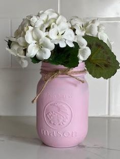 a pink mason jar filled with white flowers