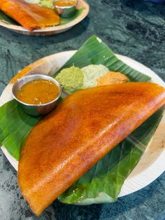 two plates with fish and dipping sauces on them