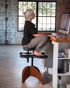 an old woman sitting at a desk on her computer