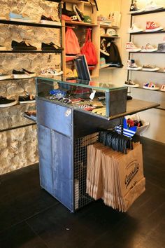 the inside of a shoe store with shoes on display and bags in front of it