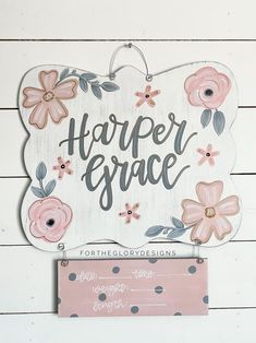 a wooden sign that says harper grace with pink flowers on it and a polka dot background