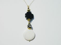 Black and ivory go so well together, with a round ivory shell Mother of Pearl pendant, (a protection stone, Mother of Pearl is a stress relieving stone; relaxing, soothing and calming to the emotions; it stimulates our intuition, imagination, sensitivity and adaptability) this ivory round shell blends well with a black onyx cross along with a mixed colored gemstone bead, and gold-tone accents; this is on a 23 inch gold-filled chain which also includes a gold-filled lobster clasp and a small gold-tone heart charm White Round Pendant Jewelry For Meditation, White Mother Of Pearl Spiritual Necklace, Squirrel Necklace, Black Agate Necklace, Mother Of Pearl Pendant, Gray Earrings, Corpus Christi Tx, Gold Filled Necklace, Mother Of Pearl Necklace