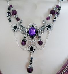 "This beautiful necklace has black glass beads, pewter silver accent beads, purple faceted beads, pewter silver bead caps, seed beads, sterling silver plated bead caps, pewter silver rhinestone accents, metal chain, sterling silver plated filigree pendant with purple faceted glass setting and rhinestones. It can be worn as a choker or adjusted up to 20\" long. Lobster clasp." Gothic Purple Metal Jewelry, Elegant Purple Jewelry With Silver Beads, Gothic Black Amethyst Jewelry, Gothic Silver Beaded Jewelry, Silver Gothic Beaded Jewelry, Bohemian Purple Jewelry With Black Beads, Purple Bohemian Jewelry With Black Beads, Ornate Handmade Purple Jewelry, Vintage Purple Round Beads Jewelry