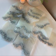 several pieces of white and silver cake sitting on top of a table next to a candle