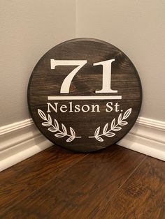 a wooden sign with the number seven on it sitting in front of a white wall