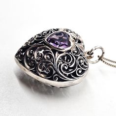 Amethyst purple gemstone heart filigree open work large puffy sterling silver necklace. Good vintage condition with little to no signs of normal vintage wear. Large heart pendant comes with sterling silver box chain. Stamped 925 on the bail. Acid tests positive for sterling silver. Gemstones tested with Presidium II gemstone tester. Necklace measures 18 inches long. Pendant measures 1 inch across with a 1/4 of an inch bail. Victorian Heart-shaped Filigree Jewelry, Sterling Silver Purple Heart Pendant Necklace, Purple Sterling Silver Heart Pendant Necklace, Purple Sterling Silver Filigree Jewelry, Ornate Sterling Silver Heart Pendant Jewelry, Purple Pendant Necklace With Filigree, Purple Filigree Pendant Necklace, Purple Filigree Pendant Jewelry, Vintage Purple Heart-shaped Jewelry