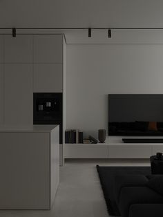 a black and white living room with couches, coffee table and television on the wall