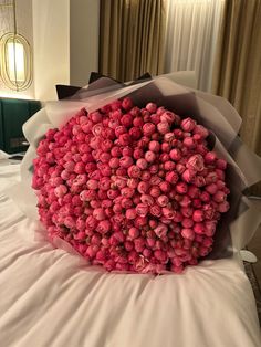 a bouquet of pink flowers sitting on top of a bed