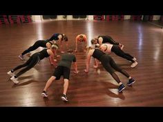 a group of women doing push ups in a gym