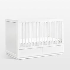 a white baby crib with two drawers