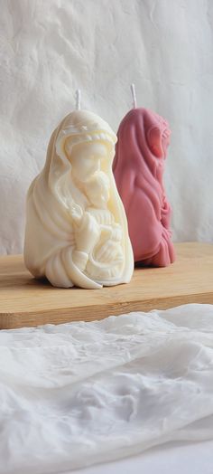 two candles sitting on top of a wooden table