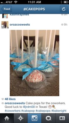 some cupcakes wrapped in plastic and tied with blue ribbon