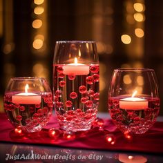 three wine glasses with candles in them on a table