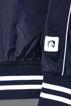 Represent TL loud and proud with the Liquid Stadium Jacket! 100% polyester raglan sleeve. White piping & front welt pockets. Felt patch at left chest & back of jacket. Stripe ribbing at collar, sleeve, bottom opening, embroidery at left pocket. Sporty Navy Nylon Track Jacket, Navy Sporty Track Jacket With Pockets, Navy Varsity Track Jacket With Ribbed Cuffs, Navy Sporty Varsity Jacket For Outdoor, Navy Sports Track Jacket With Ribbed Cuffs, Sporty Navy Varsity Jacket For Outdoor, Navy Sports Outerwear With Ribbed Cuffs, Navy Track Jacket With Ribbed Cuffs For Sports, Navy Track Jacket With Ribbed Cuffs For Streetwear