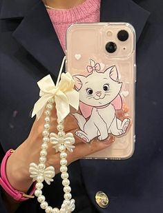 a person holding a cell phone case with a cat on it and pearl necklaces