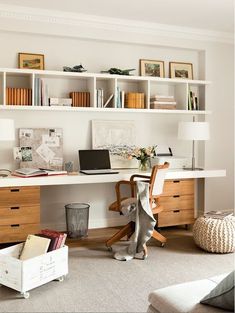 a desk with a laptop computer on top of it next to a chair and ottoman