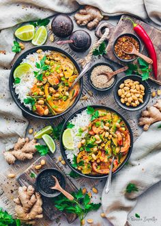 three black bowls filled with thai food and garnished with cilantro, limes, cashews