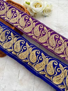 two purple and gold colored hair combs sitting next to each other on a table