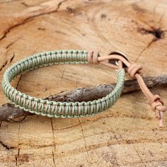 two green bracelets sitting on top of a piece of wood