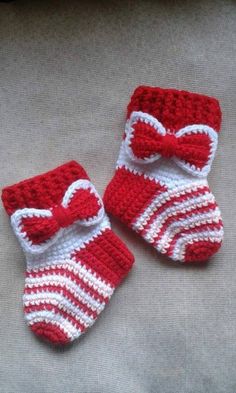 two red and white crocheted baby booties with bows