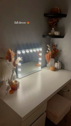 a white desk topped with a vanity mirror and lots of lights on top of it