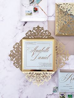 the wedding stationery is laid out on top of the marble table with gold foil