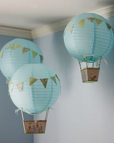 three blue paper lanterns hanging from the ceiling in a room with light blue walls and white trimmings