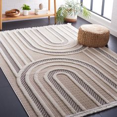 a white rug with an abstract design on the floor in front of a large window