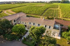 an aerial view of a large house in the middle of a field with lots of trees