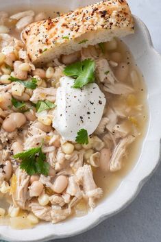 a white bowl filled with chicken and bean soup