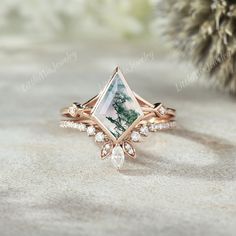 a close up of a ring with a stone in the middle and diamonds around it