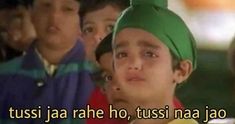 two young boys wearing green turbans are looking at the camera with other children in the background