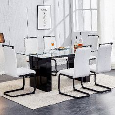 a glass dining table with white chairs