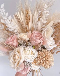 a vase filled with flowers and feathers on top of a table