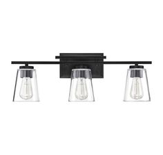 three light bathroom fixture with clear glass shades and black metal fixtures on an isolated wall