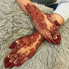 two hands with henna tattoos on them