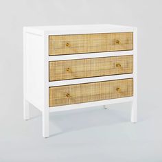 a white and wicker dresser with three drawers