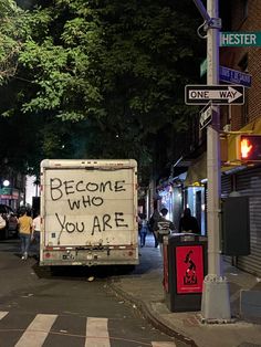 a truck parked on the side of a street with graffiti written on it's back